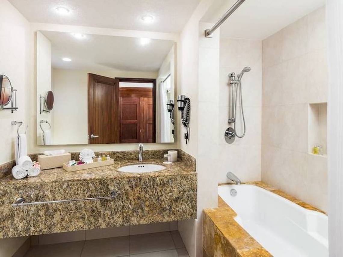 Badezimmer im BlueBay Grand Esmeralda Hotel mit Badewanne, Dusche und Waschbecken.