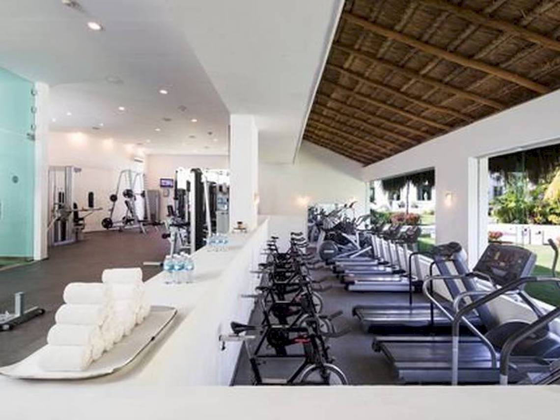 Fitnesscenter im BlueBay Grand Esmeralda Hotel mit vielen Laufbändern und Hanteln.