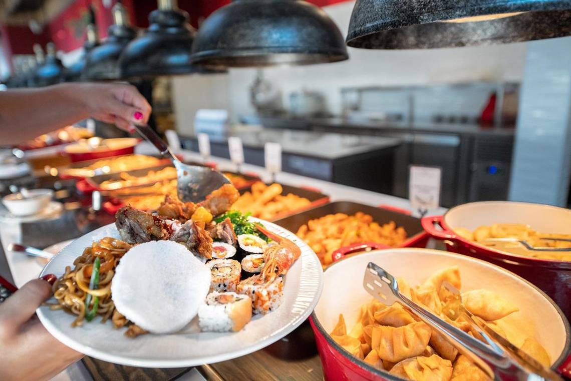Buffet-Tisch im Lyttos Beach Hotel mit verschiedenen Gerichten, darunter Sushi, gebratenes Fleisch und frittiertes Gemüse.