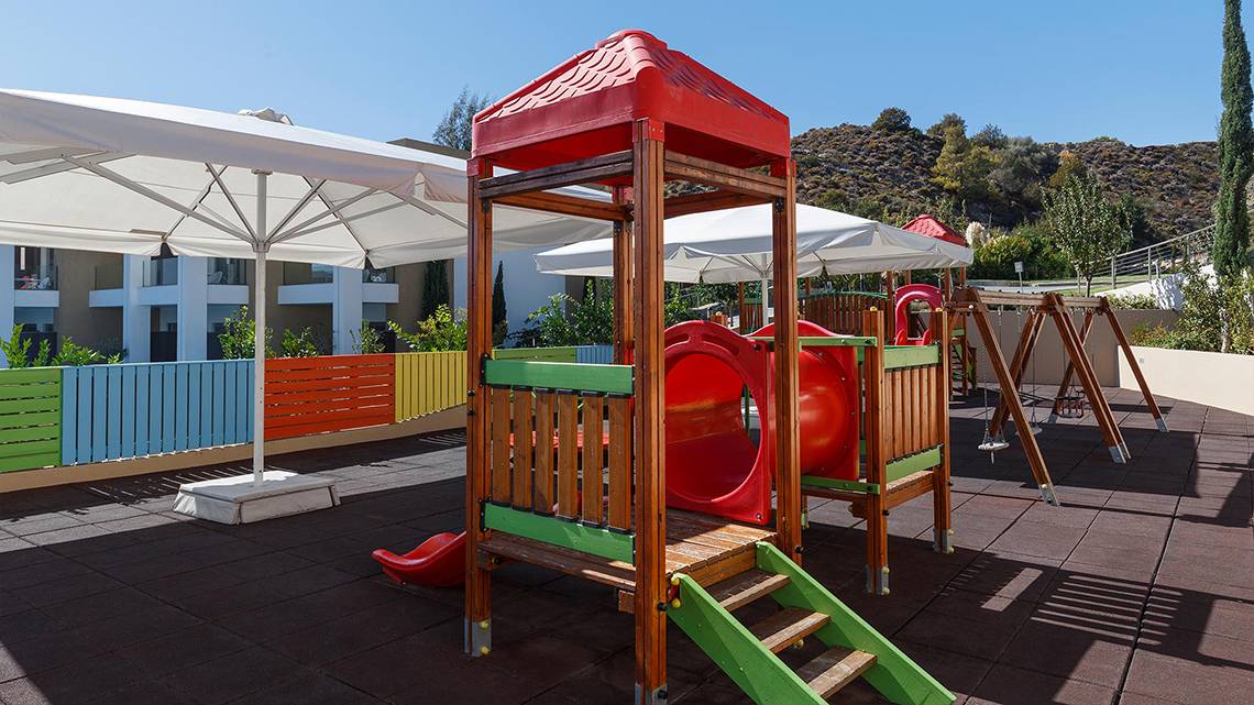 Kinderspielplatz im Princess Andriana Resort & Spa mit Rutsche und Spielgeräten.