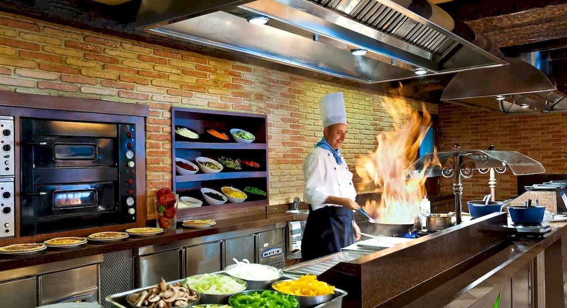 Koch im Occidental Playa de Palma Hotel mit Flammen beim Kochen in der Küche