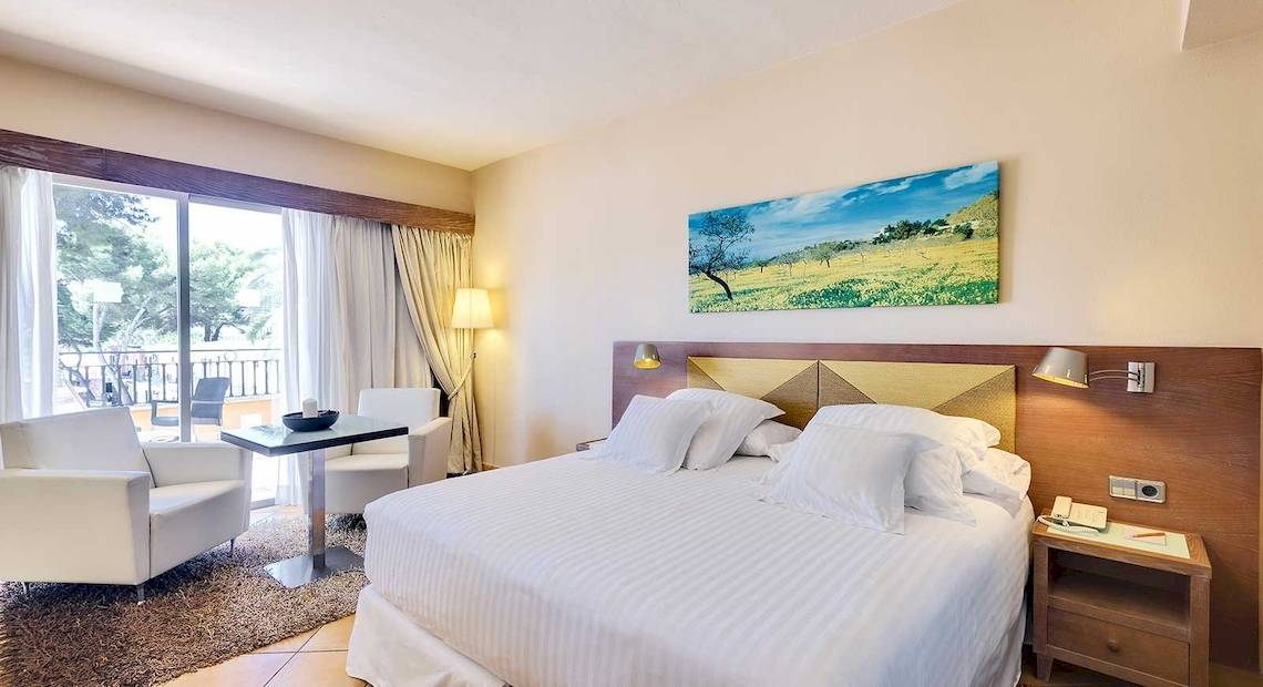 Hotelzimmer im Occidental Playa de Palma mit Bett, Tisch, Stühlen und Ausblick.