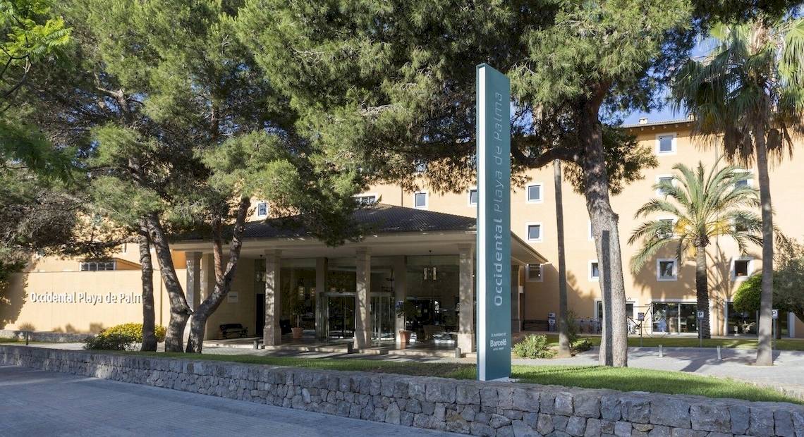 Eingang des Occidental Playa de Palma Hotels mit Bäumen und einem grünen Schild
