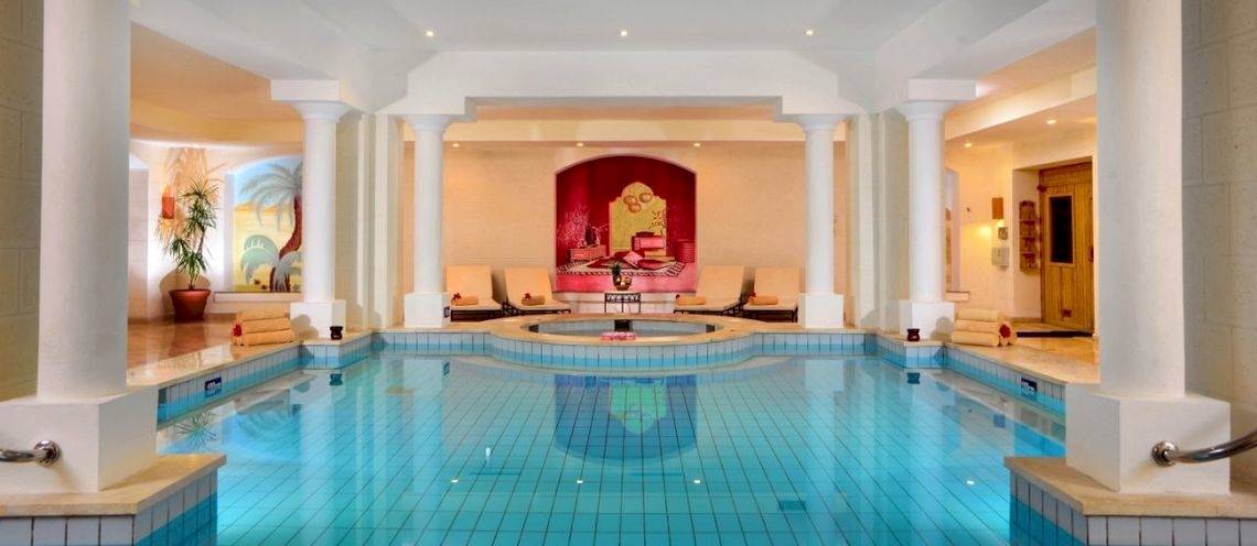 Innenpool des Steigenberger Coraya Beach Hotels mit Loungebereich und Dekor.