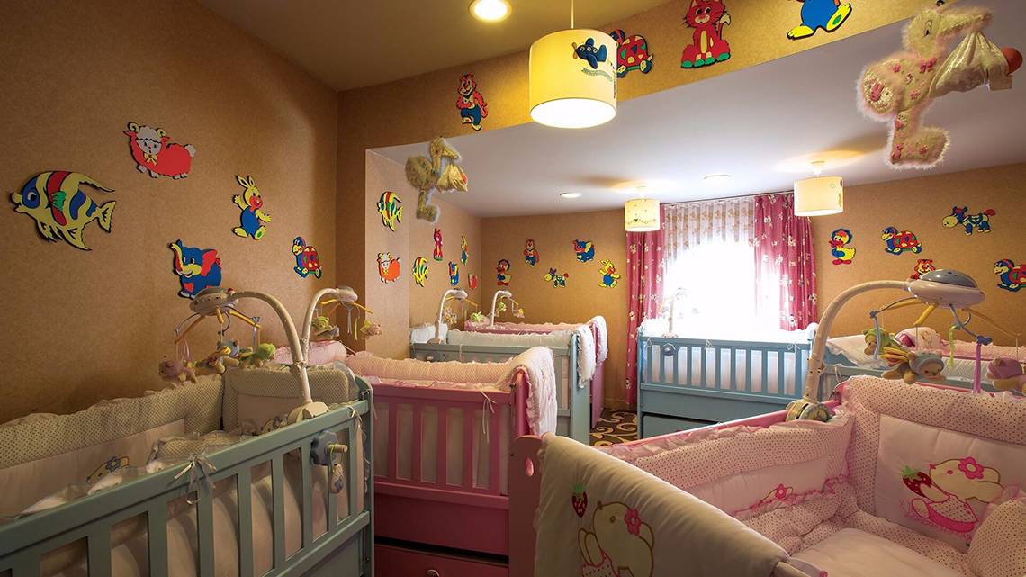 Kinderzimmer im Cornelia Diamond Golf Resort & Spa mit farbenfrohen Wandaufklebern und mehreren Babybetten.