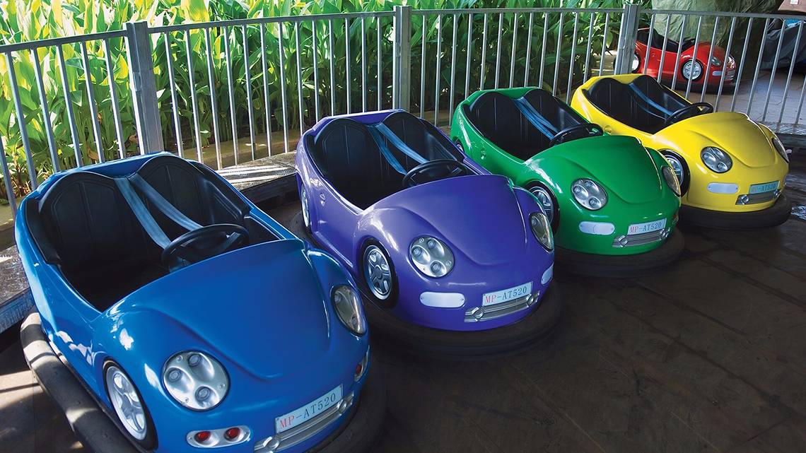 Fünf bunte Bungee Autos stehen nebeneinander auf einem Parkettboden im Cornelia Diamond Golf Resort & Spa.