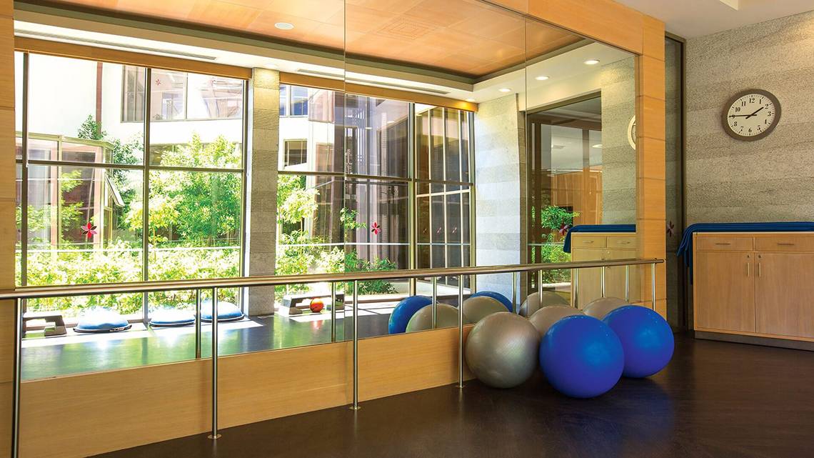 Fitnessbereich im Cornelia Diamond Golf Resort & Spa mit großen Fenstern und Fitnessgeräten.
