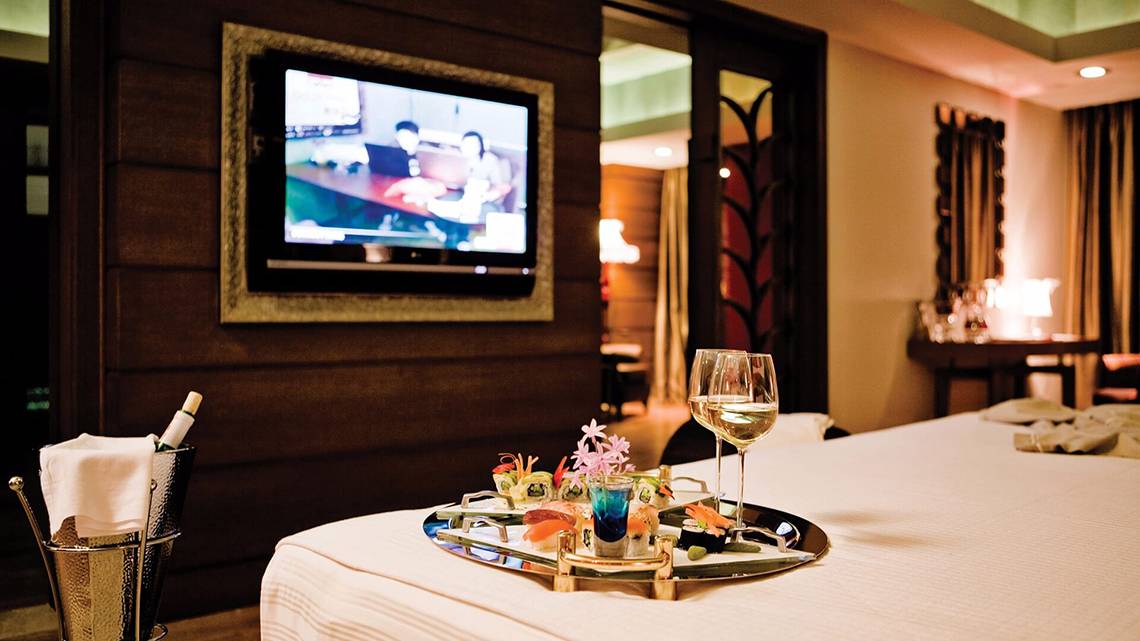 Zimmer im Cornelia Diamond Golf Resort & Spa mit Bett, Fernseher, Tisch und Getränken.