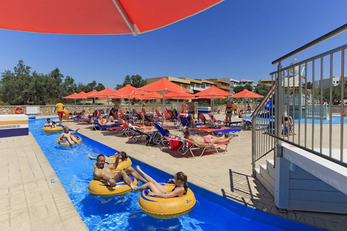 Schwimmbad im Atlantica Mikri Poli Rhodes Hotel mit Schlauchrutschen und Sonnenschirmen.