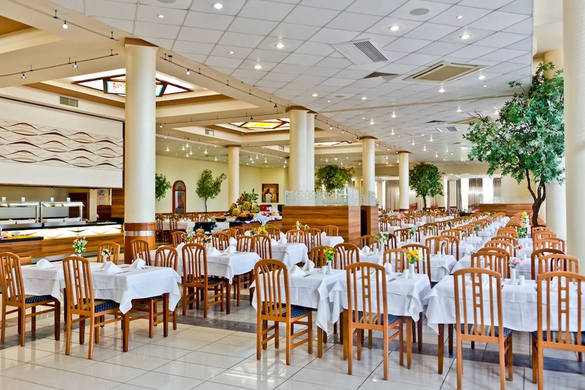 Restaurant des DIT Evrika Beach Club mit gedeckten Tischen und Blumendekor