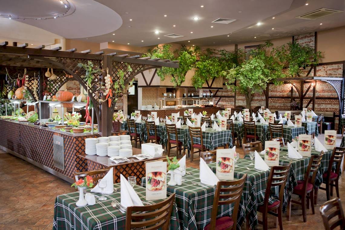 Innenbereich des DIT Evrika Beach Club Restaurants mit gedeckten Tischen und serviertem Essen.
