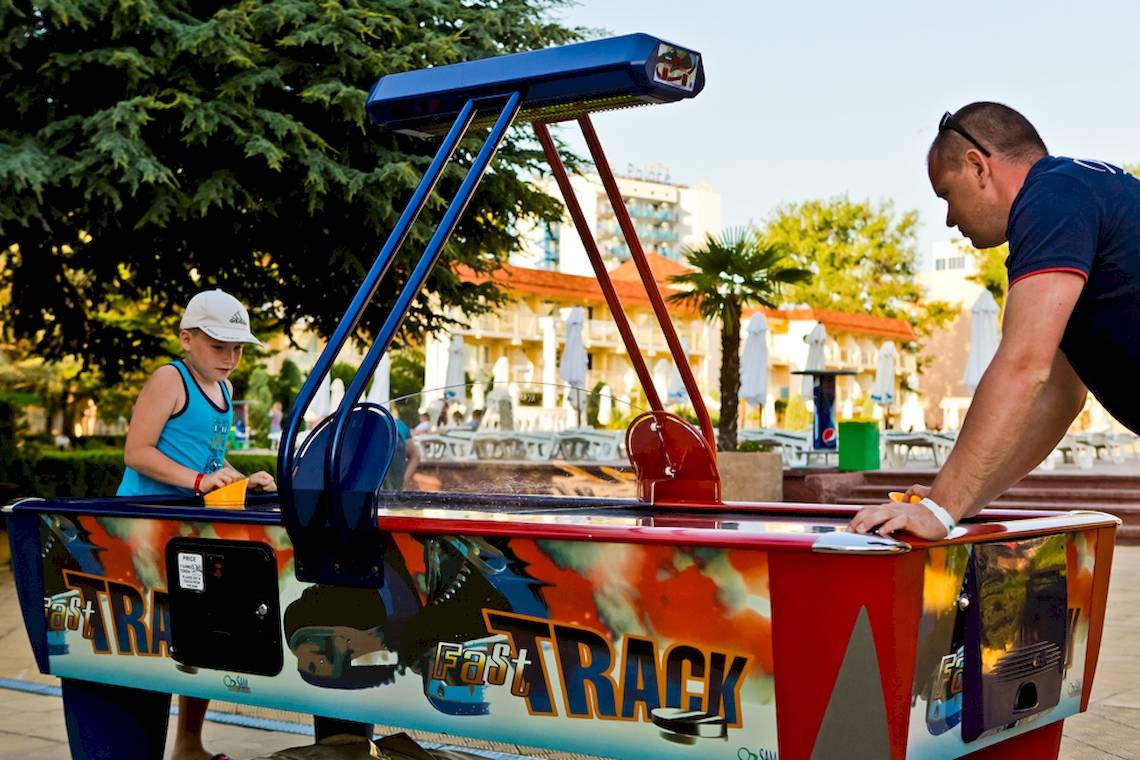 Ein Mann und ein Junge spielen Air Hockey im DIT Evrika Beach Club.