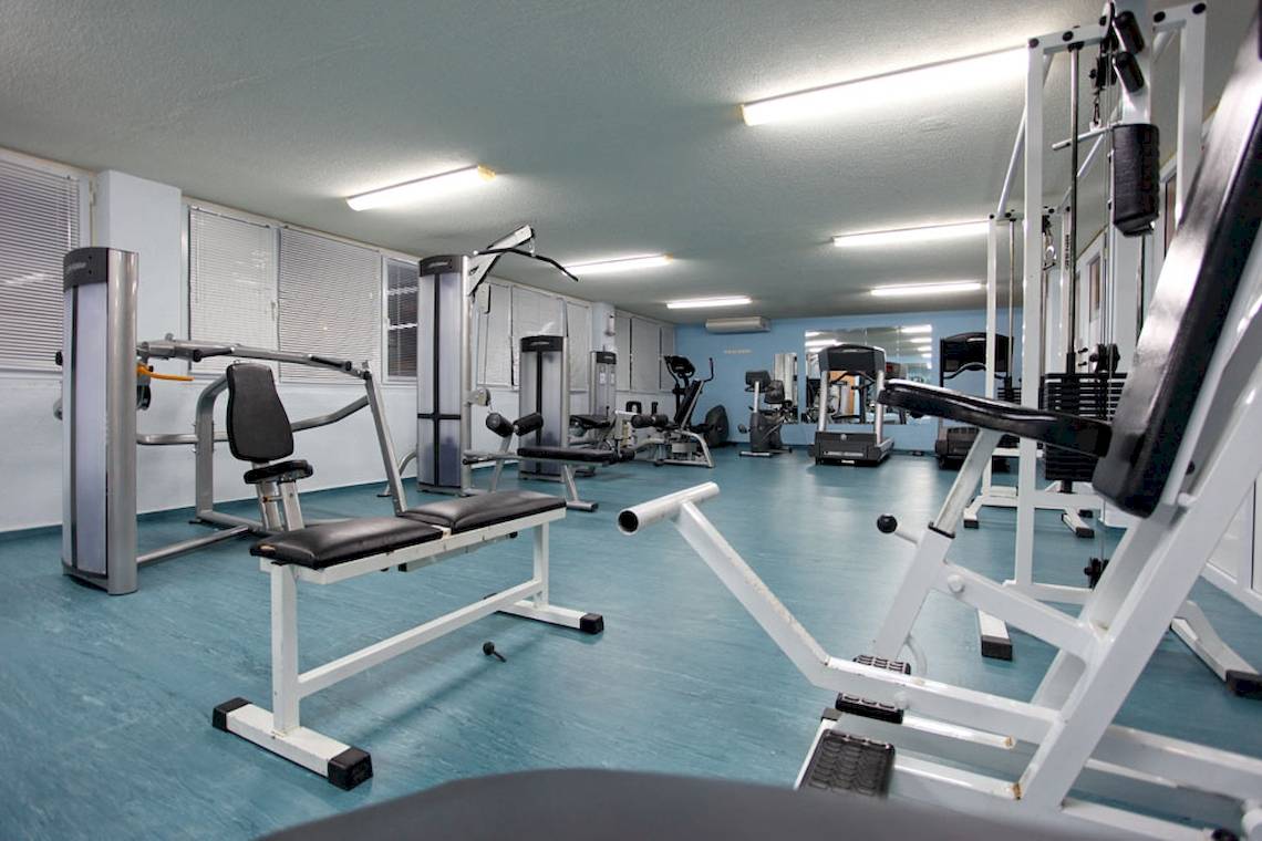 Fitnessraum im DIT Evrika Beach Club mit verschiedenen Geräten und blauen Boden