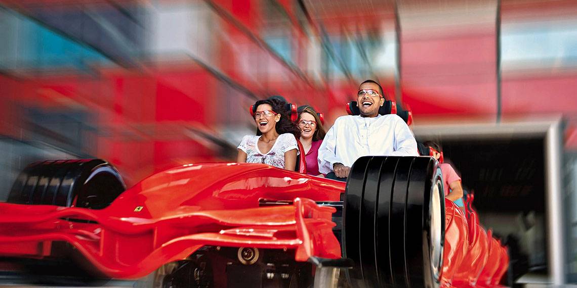 Gruppe von Gästen im roten Ferrari-Rennwagen im Crowne Plaza Abu Dhabi Yas Island Hotel
