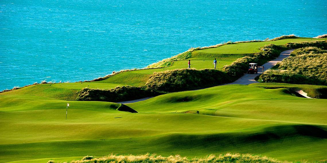 Golfplatz mit Blick auf das Meer und Golfern in der Ferne