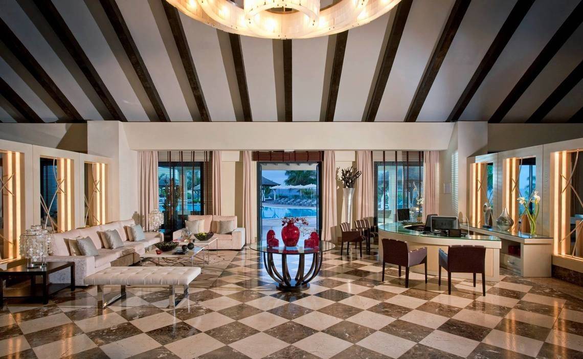 Empfangsbereich des Gran Melia Palacio de Isora mit modernen Möbeln und Blick auf den Pool.