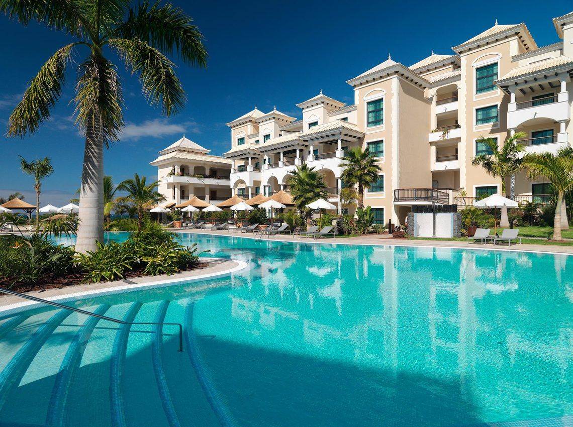 Außenpool des Gran Melia Palacio de Isora Hotels mit Loungeliegen und Palmen