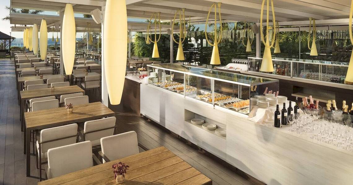 Restaurantbereich des Gran Melia Palacio de Isora mit Tischen, Stühlen und Speisen