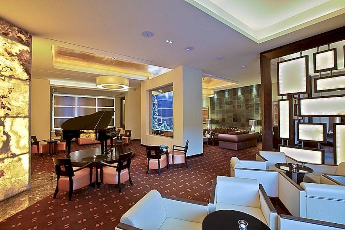 Hotellobby des Gran Melia Palacio de Isora mit Klavier, Sofas und Tischen.
