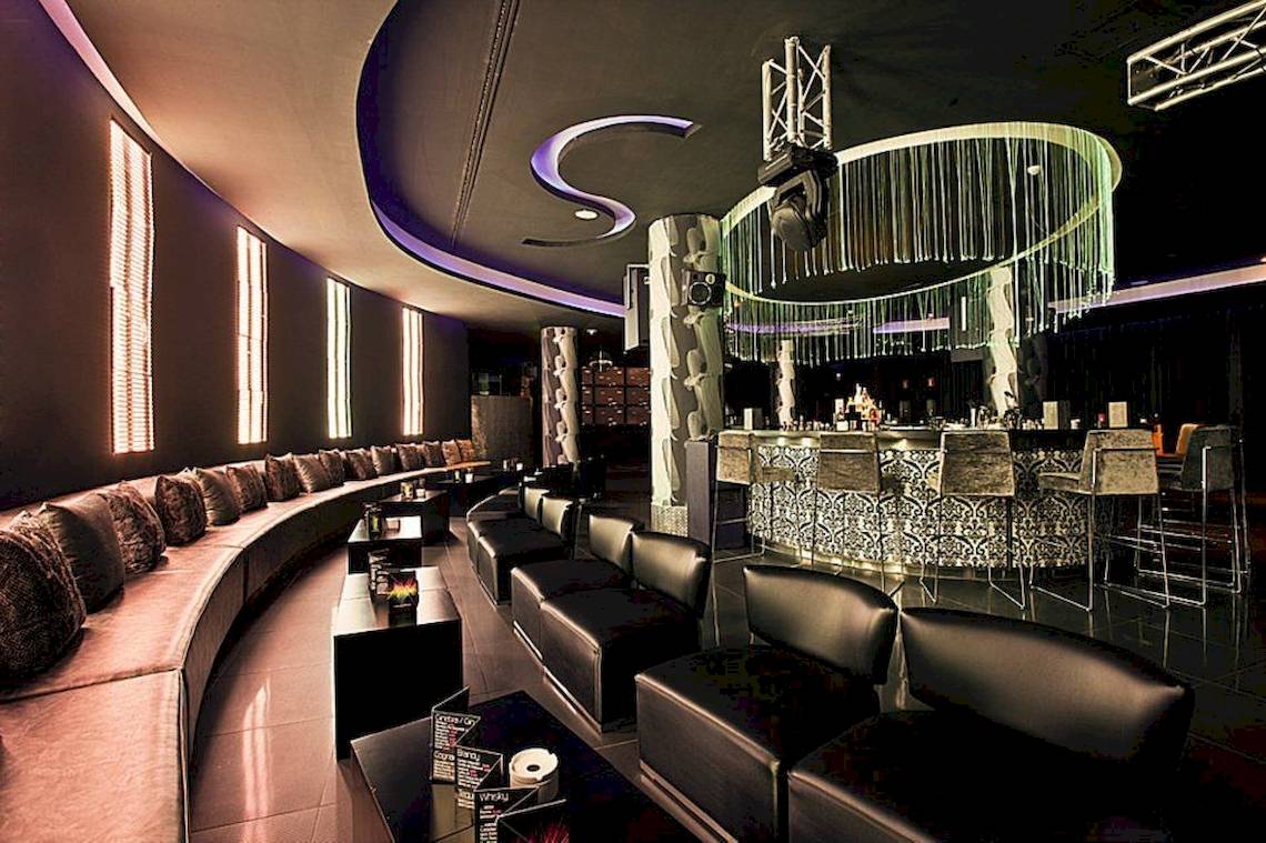 Das elegante Interieur des Gran Melia Palacio de Isora Hotels mit gepolsterten Sofas und einer Bar.