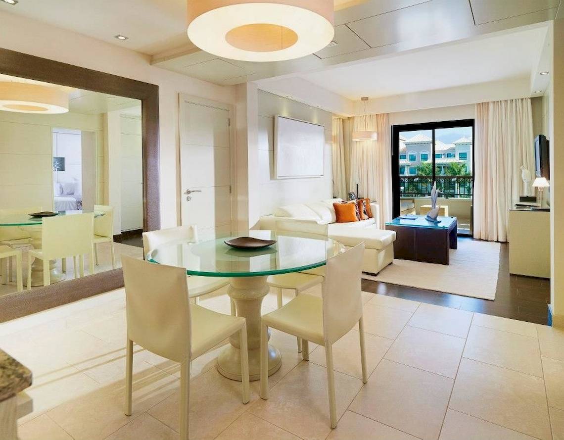Innenbereich des Gran Melia Palacio de Isora mit Esstisch und Wohnzimmer.