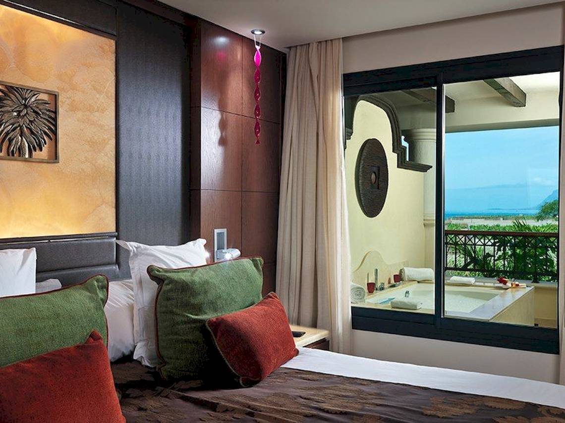 Zimmer im Gran Melia Palacio de Isora mit Blick auf einen Whirlpool und das Meer.