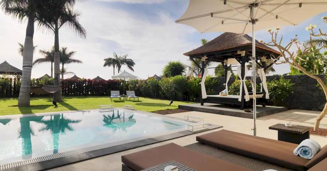 Pool im Freien mit einem Pavillon und Liegestühlen im Gran Melia Palacio de Isora Hotel.