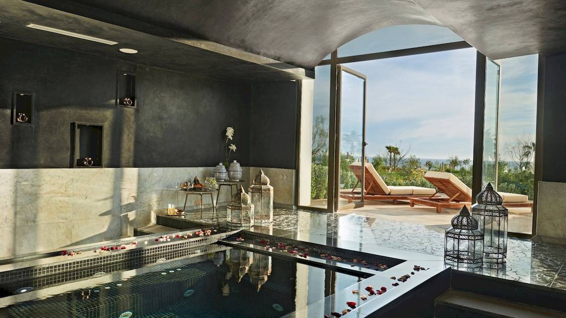 Luxuriöser Pool im Hyatt Place Taghazout Bay mit Blick auf das Meer und Lounge-Bereich draußen.