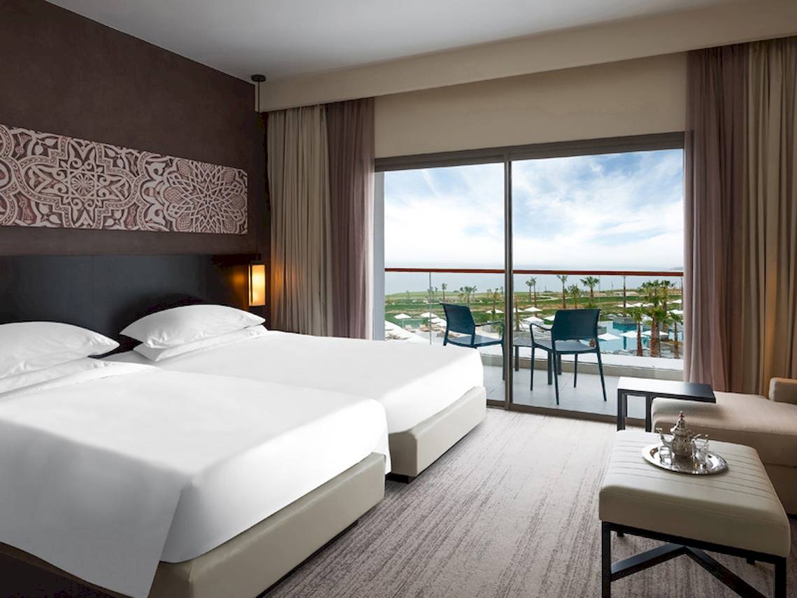 Doppelbett-Zimmer im Hyatt Place Taghazout Bay mit Blick auf den Pool und die Landschaft.