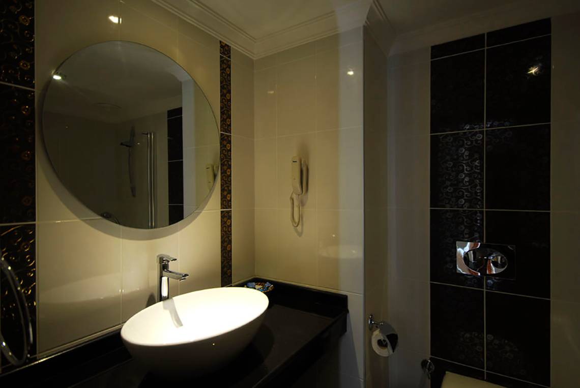 Badezimmer im Meril Hotel mit Spiegel und Waschbecken.