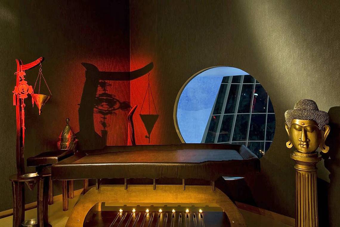 Innenansicht des Spa-Raums im Blue Waters Club Hotel mit Buddha-Statue und Kerzen.