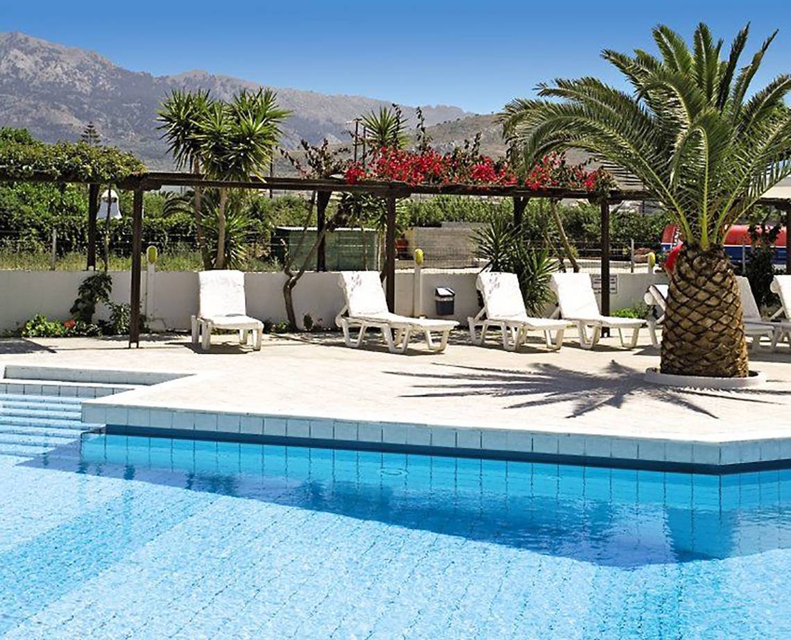 Außenpool des Golden Star Hotels mit Liegestühlen und Palmen im Hintergrund.