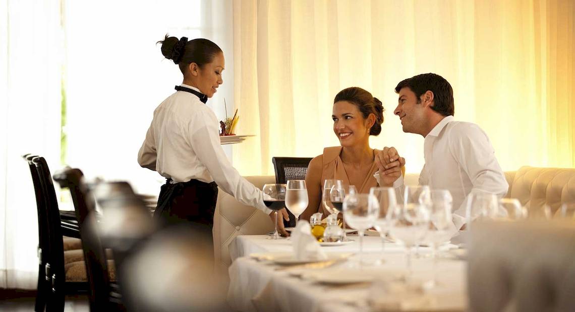 Ein Kellner serviert ein Paar im Restaurant des Barcelo Maya Palace