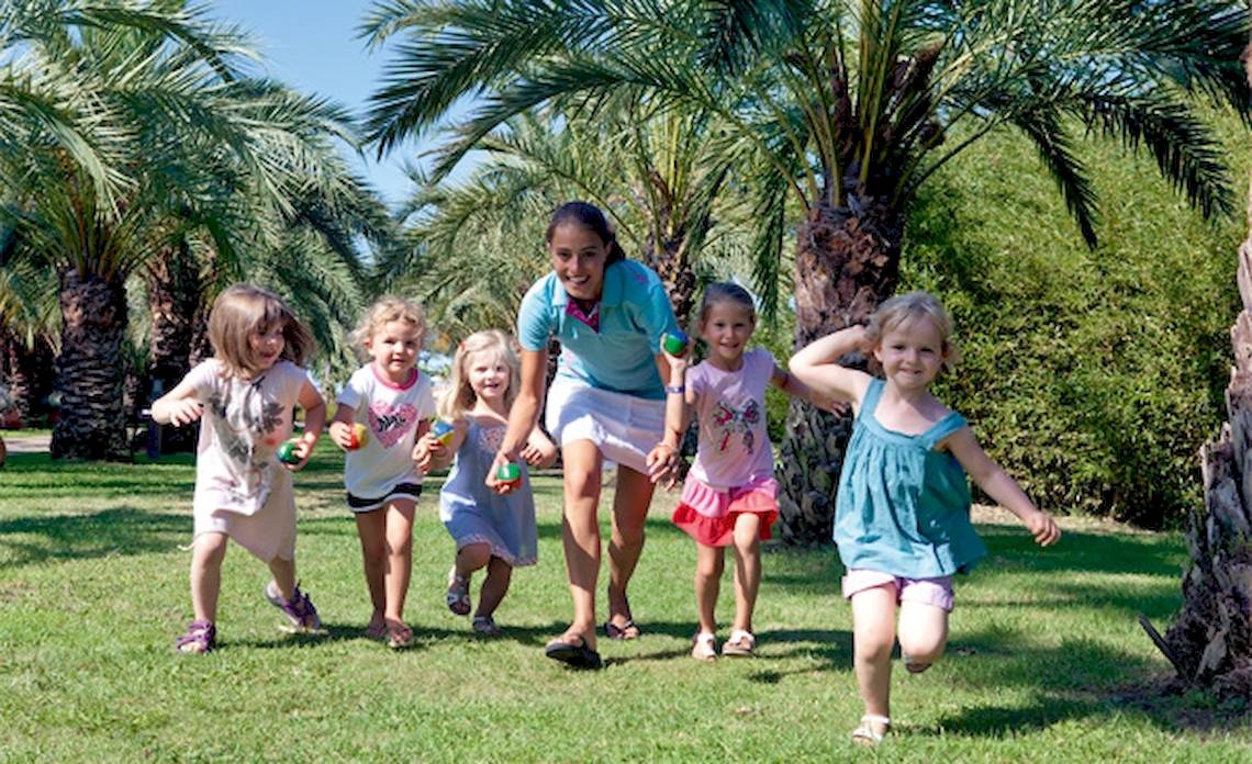 Kleine Kinder laufen mit Bällen im Freien im Belambra Clubs Pineto.