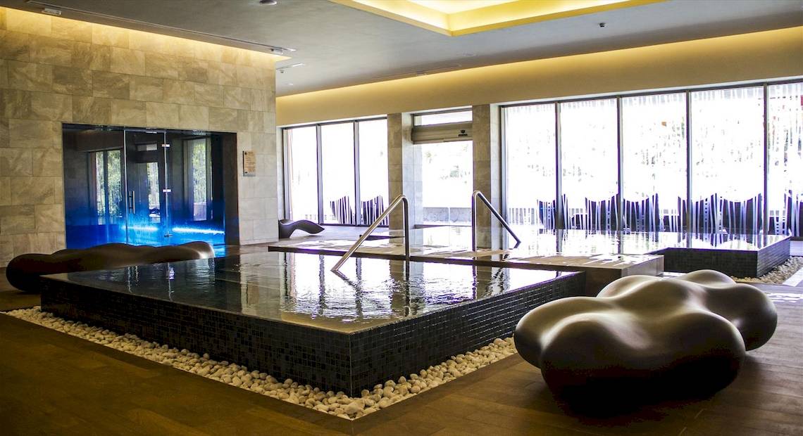 Wellnessbereich im Barcelo Maya Palace Hotel mit einem großen Pool und Loungemöbeln.