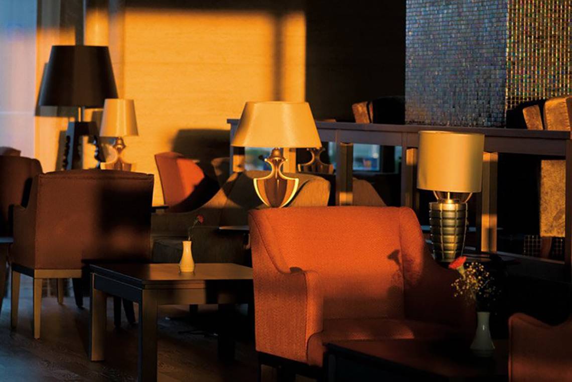 Sitzecke im Hotel Melas Lara mit mehreren Lampen und Tischen.