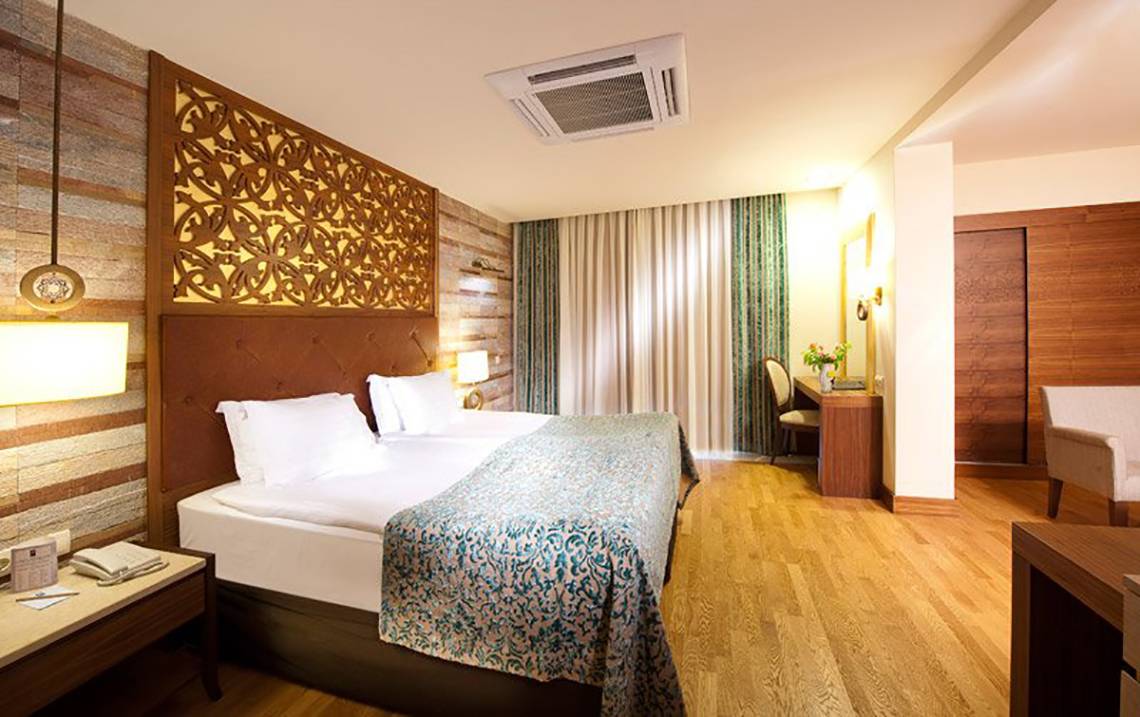 Schlafzimmer im Melas Lara Hotel mit Doppelbett, Dekor und Klimaanlage.