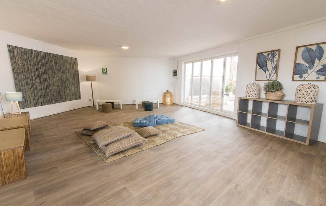 Innenbereich des Cala Martina by Llum Hotels mit Holzboden, großen Fenstern und Möbeln.