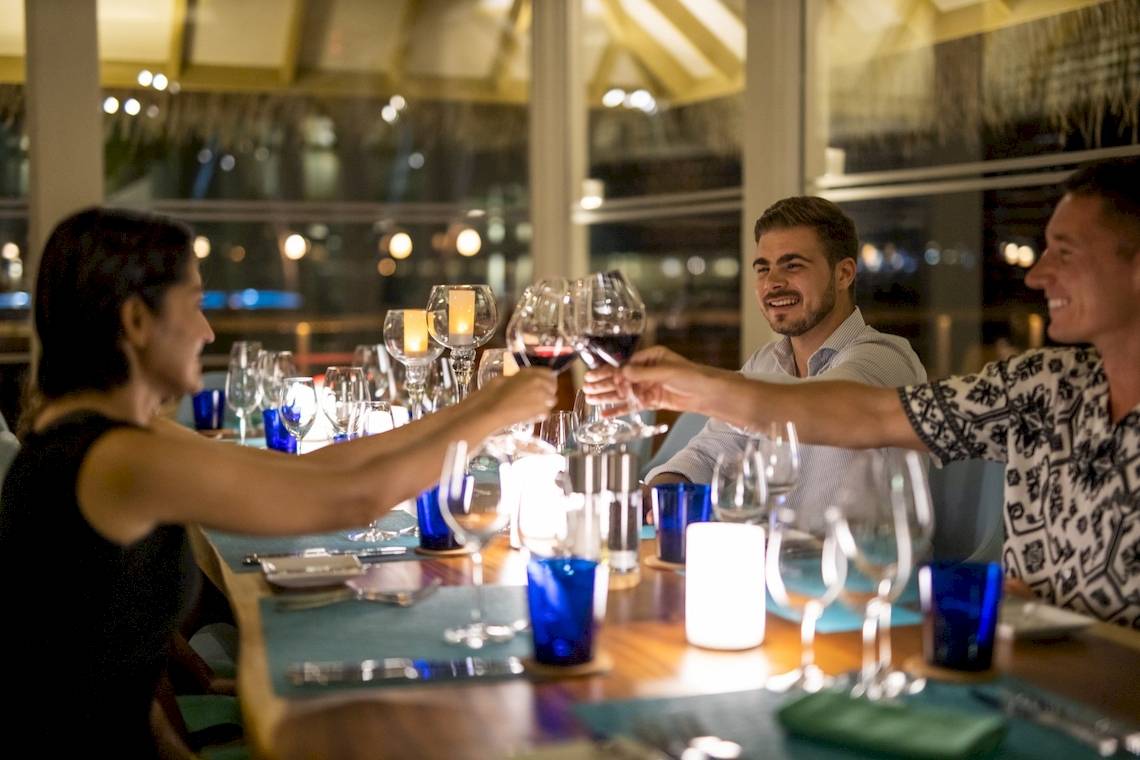 Gäste trinken im Sun Siyam Iru Veli Hotel auf die Zukunft an.