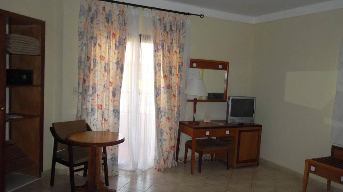 Das Zimmer im ROC Arenas Doradas Hotel mit Tisch, Stuhl, Fernseher und Schreibtisch.