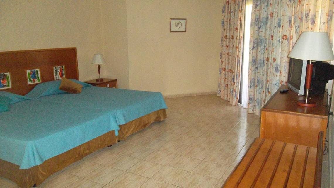 Zweibettzimmer im ROC Arenas Doradas Hotel mit blauen Laken und Dekor an der Wand.