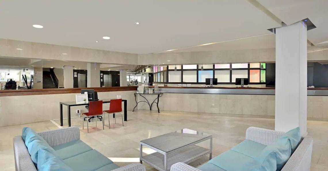 Innenbereich der Lobby des Sol Barbados Hotels mit Rezeptionstresen, Tischen und Stühlen.