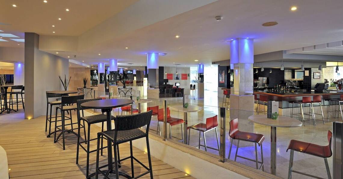 Innenbereich des Sol Barbados Hotels mit Bar, Tischen und Stühlen.