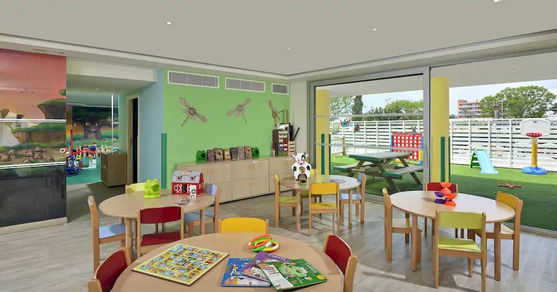 Innenansicht des Kinderspielzimmers im Sol Barbados Hotel mit bunten Tischen, Stühlen und Spielzeug.