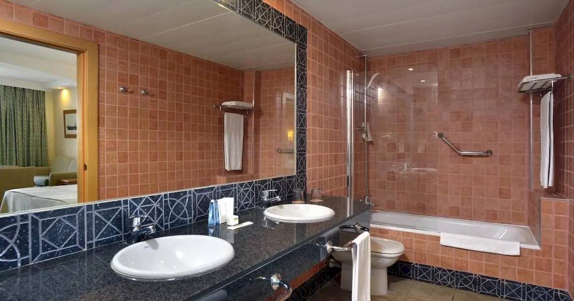 Hotel Sol Barbados Badezimmer mit zwei Waschbecken, Badewanne und Toilette.