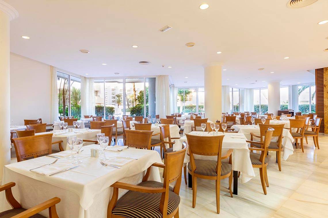 Restaurant im Hipotels Bahia Grande Hotel mit vielen gedeckten Tischen und Stühlen.