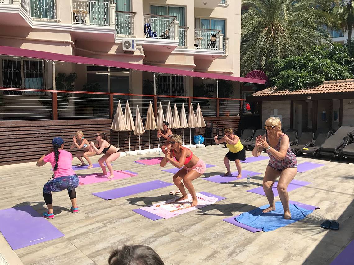 Gruppe von Frauen, die Yoga auf Matten vor dem Riviera Hotel & Spa machen.