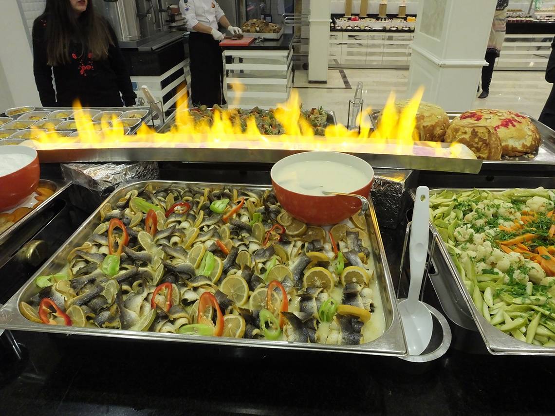 Buffet-Tisch im Riviera Hotel & Spa mit Fisch, Gemüse und Flammen
