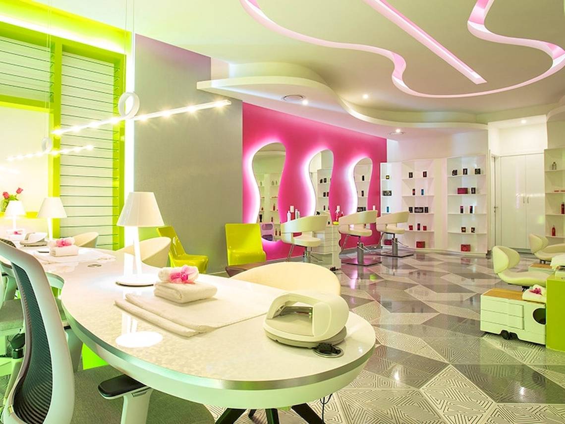 Innenansicht des Temptation Cancun Resort Nagelstudios mit pinken Wänden und grünen Akzenten.
