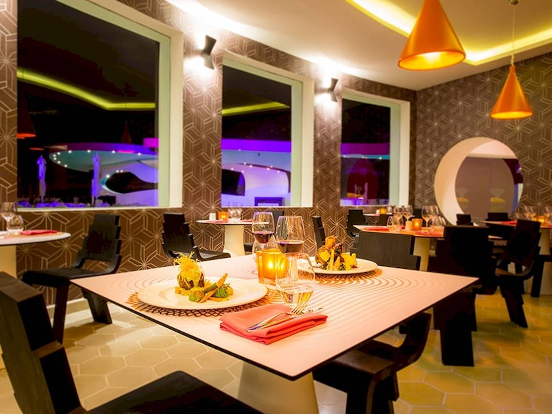 Innenbereich des Restaurants im Temptation Cancun Resort mit gedeckten Tischen und modernem Design.